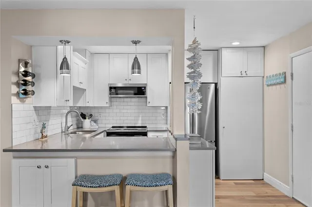 a kitchen with stainless steel appliances granite countertop a refrigerator and a sink
