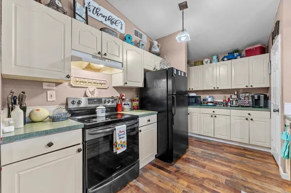 a kitchen with refrigerator a stove and cabinets