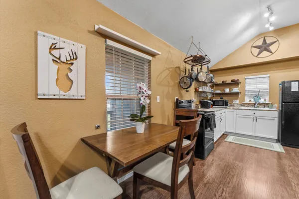 a kitchen with a table chairs and a painting
