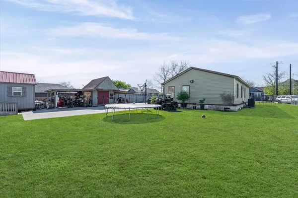 a view of an house with a big yard and large trees