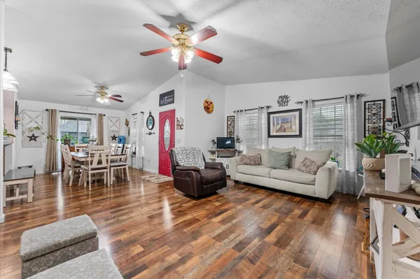 a living room with furniture and wooden floor