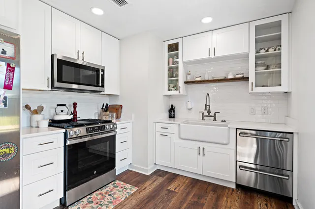 a kitchen with stainless steel appliances white cabinets and stove