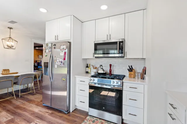 a kitchen with stainless steel appliances a stove microwave and refrigerator
