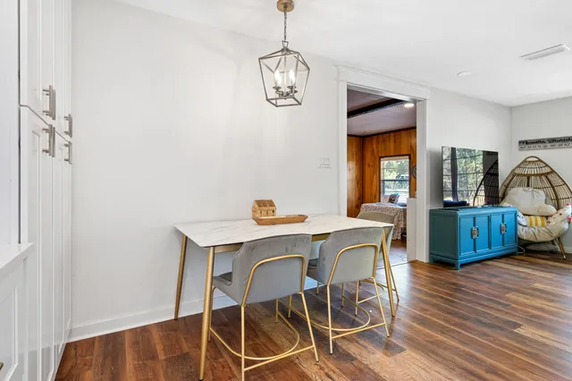 a view of a dining room with furniture a chandelier and wooden floor