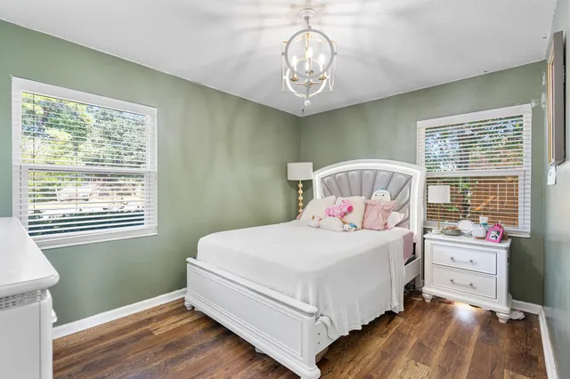 a bedroom with a bed wooden floor and window
