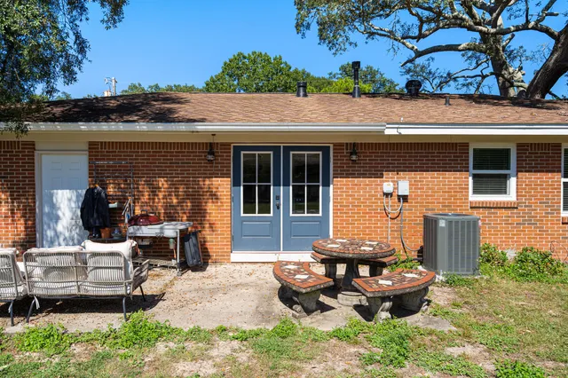 a view of a backyard with table and chairs potted plants and a wooden fence