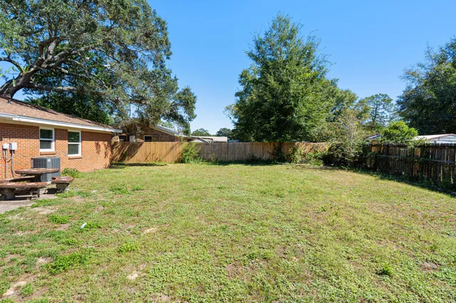an aerial view of residential houses with outdoor space and trees