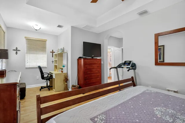 a bedroom with a bed and wooden floor