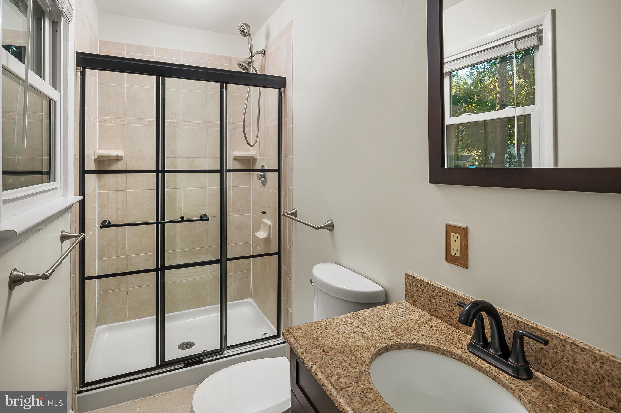 1811 Underwood Road Gambrills, MD 21054 - Photo 30 of 46 a bathroom with a granite countertop toilet sink mirror and shower