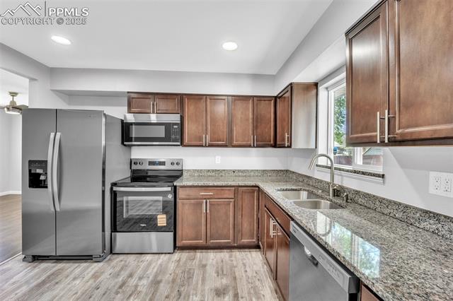 2004 Monterey Road Colorado Springs, CO 80910 - Photo 3 of 27 Kitchen with appliances with stainless steel finishes, light wood-style flooring, light stone countertops, and recessed lighting