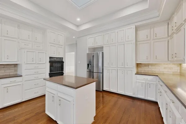 a kitchen with granite countertop white cabinets and stainless steel appliances