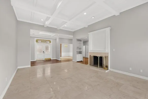 an empty room with fireplace and windows