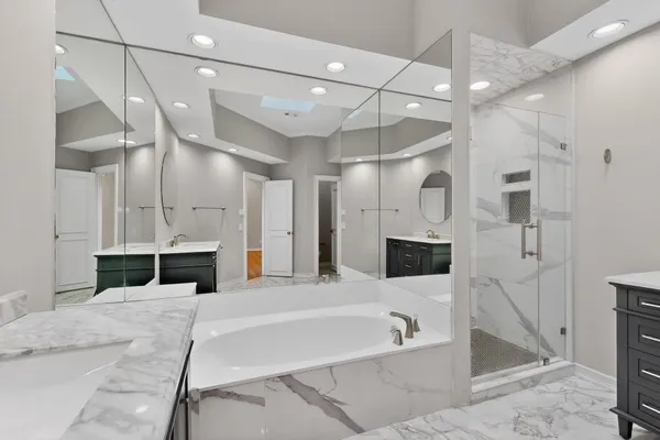 a spacious bathroom with a granite countertop sink a mirror and shower