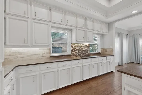 a kitchen with granite countertop white cabinets and sink