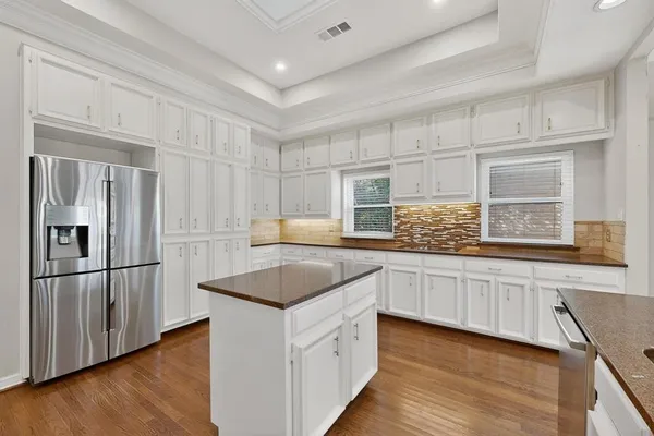 a kitchen with granite countertop white cabinets and white appliances