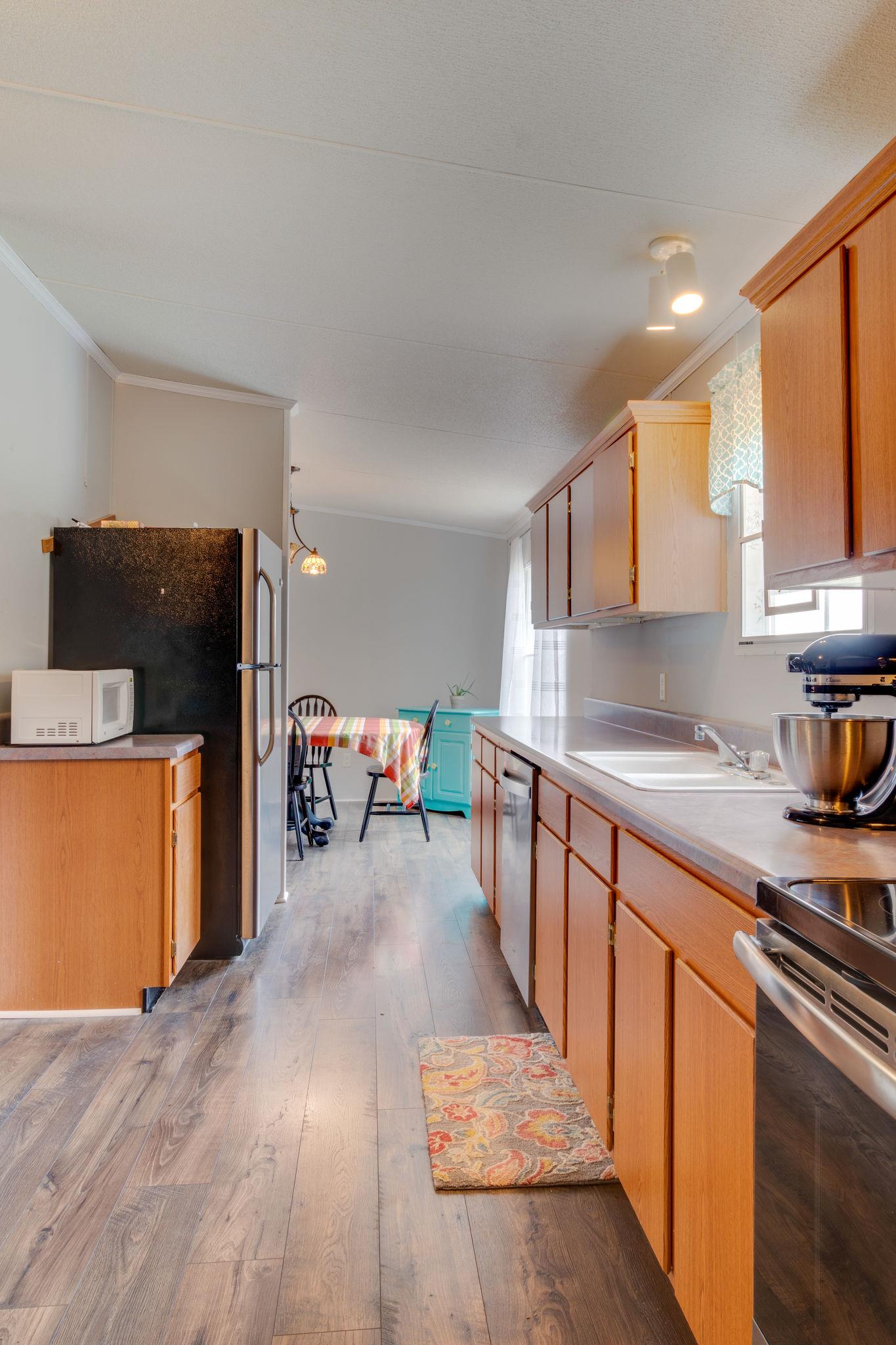 3245 Les Chappell Road Spring Hill, TN 37174 - Photo 8 of 22 a kitchen with stainless steel appliances kitchen island granite countertop a refrigerator and a stove top oven