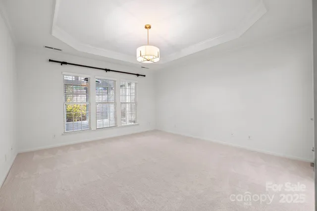 en empty room with windows and ceiling fan