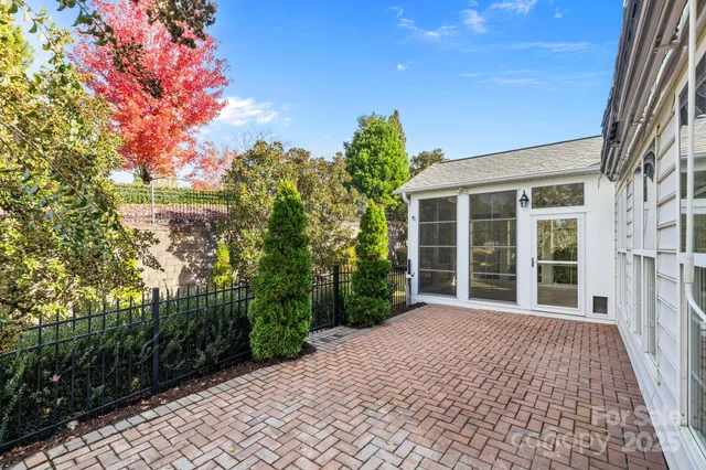 a view of a white house with a yard and plants next to a yard