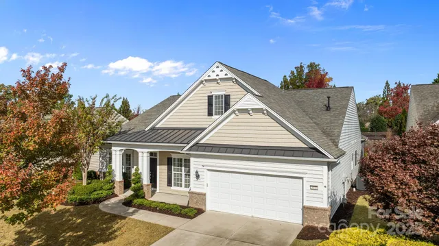 an aerial view of a house with swimming pool and large trees
