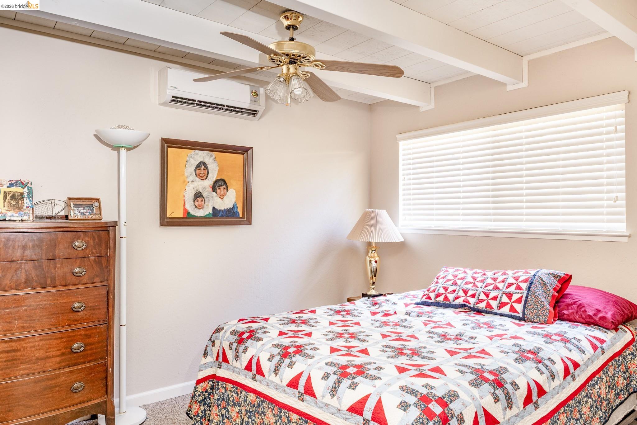 19711 Pleasantview Drive Groveland, CA 95321 - Photo 22 of 39 Room featuring a ceiling fan, exposed beam ceiling, wall-mounted air conditioning unit, and window with horizontal blinds