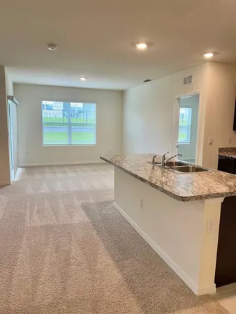 a bathroom with a granite countertop sink and a large mirror