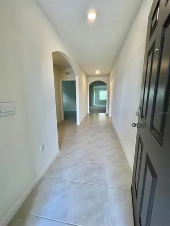 a view of a hallway with wooden floor and a bathroom