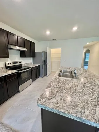 a kitchen with stainless steel appliances granite countertop a sink stove and refrigerator