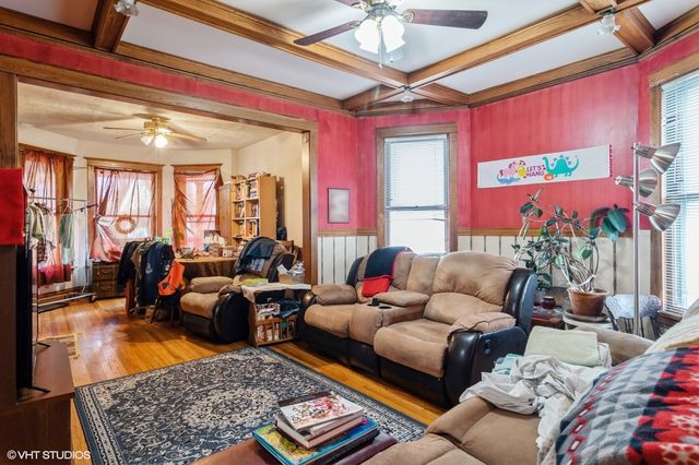 a living room with furniture a chandelier and a dining table
