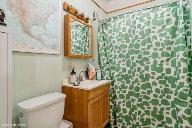 a bathroom with a sink a toilet and shower curtain