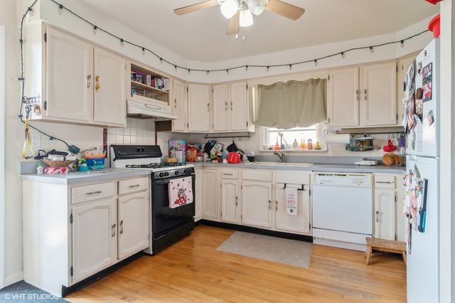 a kitchen with white cabinets stainless steel appliances and sink