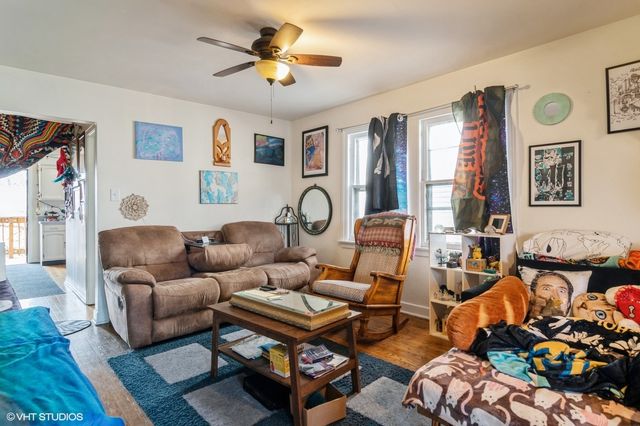 a living room with furniture a rug and wall paintings