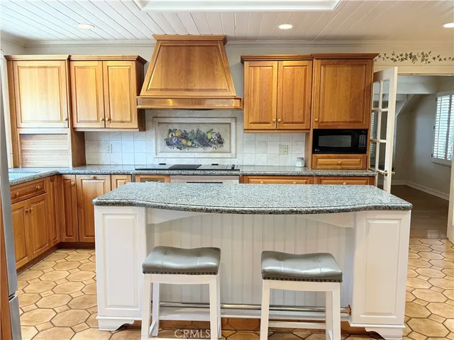 a kitchen with granite countertop a stove a sink and a microwave