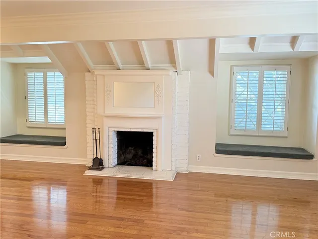 a view of a livingroom with wooden floor and a fireplace