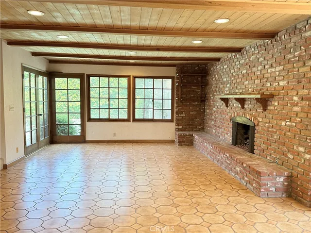 a view of an empty room with a fireplace and a window
