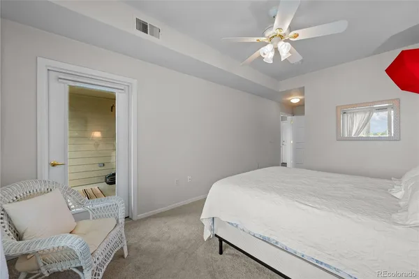 a spacious bedroom with a bed and a chandelier