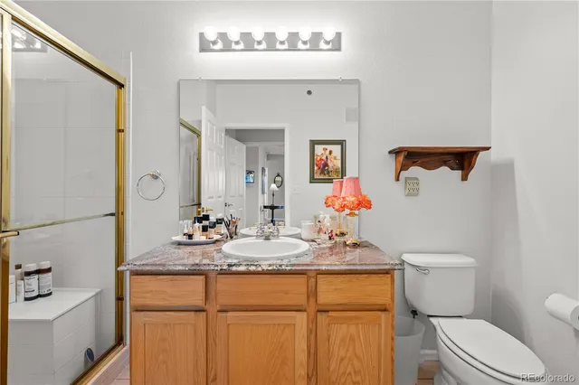 a bathroom with a granite countertop sink mirror vanity and toilet