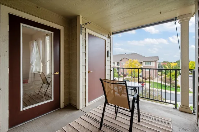a view of a balcony with furniture and wooden floor