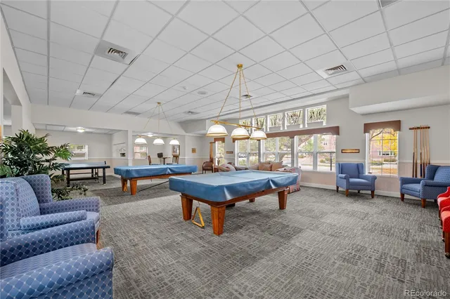 a living room with furniture a pool table and a large window
