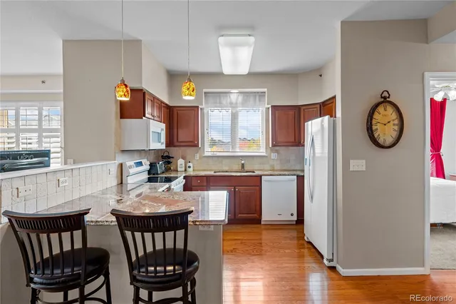 a kitchen with a dining table chairs and refrigerator