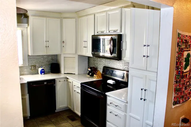 a kitchen with stainless steel appliances granite countertop a refrigerator stove and sink