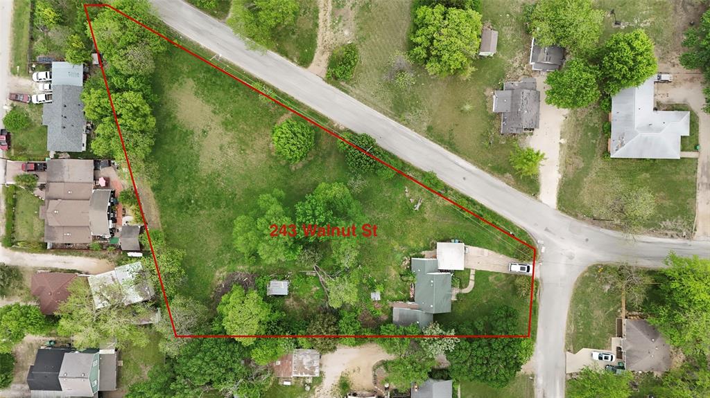 an aerial view of residential house with outdoor space and trees all around
