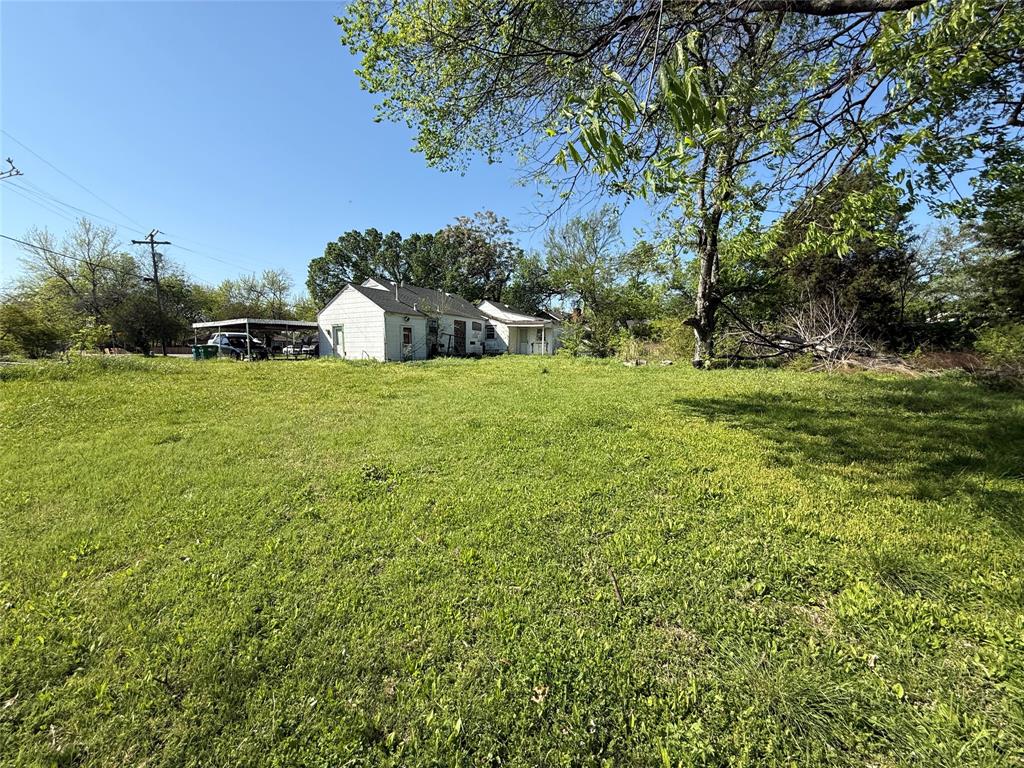 243 Walnut Street Wilmer, TX 75172 - Photo 13 of 20 a backyard of a house with plants and large trees