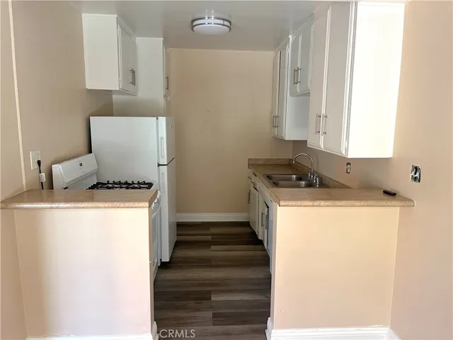 a kitchen with granite countertop white cabinets and white appliances