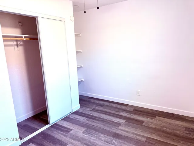 a view of empty room with wooden floor and window