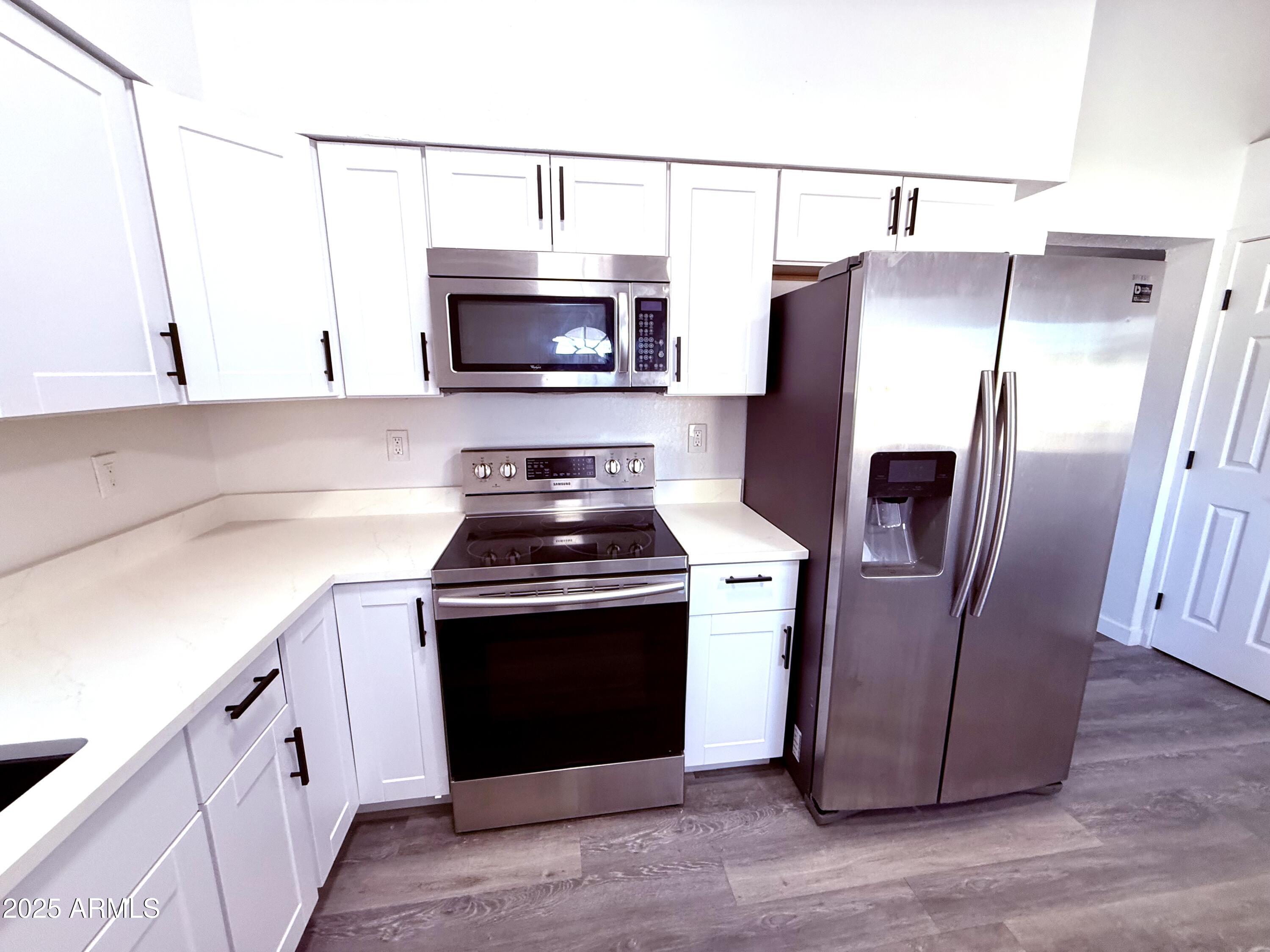 1009 East Chipman Road Phoenix, AZ 85040 - Photo 3 of 30 a kitchen with stainless steel appliances granite countertop a stove a refrigerator and a microwave