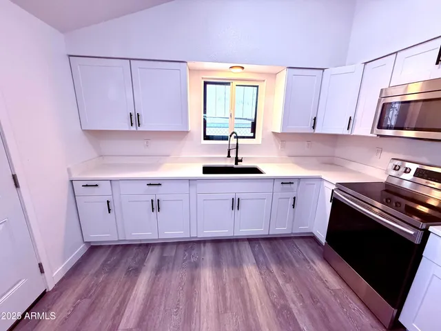 a kitchen with a sink window and stainless steel appliances