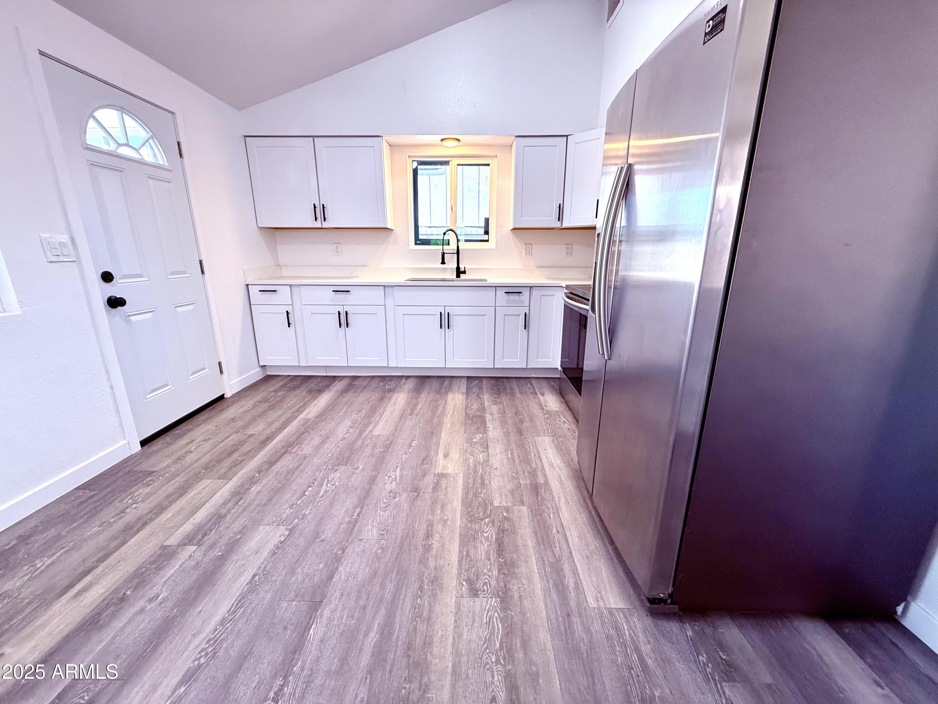 1009 East Chipman Road Phoenix, AZ 85040 - Photo 6 of 30 a kitchen with cabinets a sink and wooden floor