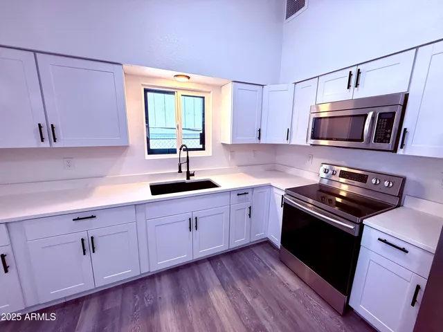 a kitchen with sink cabinets and stainless steel appliances