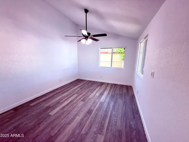 a view of empty room with a window and wooden floor