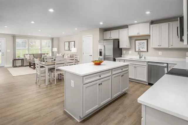 a kitchen with a sink stove cabinets and wooden floor